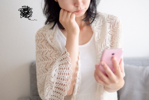 スマホ操作に悩む女性のイメージ